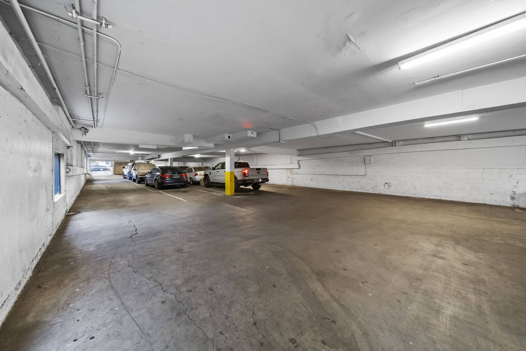 A parking garage with a concrete floor and white walls.